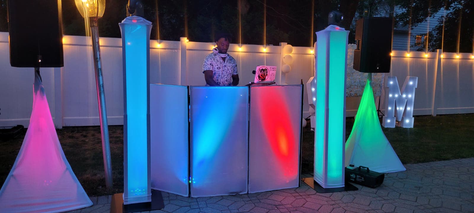 Outdoor DJ setup with colored lights